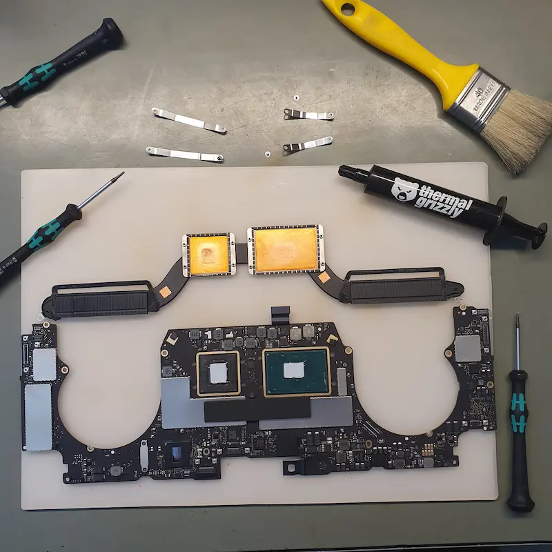 Konserwacja układu chłodzenia w MacBook Pro: wymiana pasty termoprzewodzącej na procesorze i chipsecie graficznym, widoczne radiatory, płyta główna i narzędzia serwisowe.