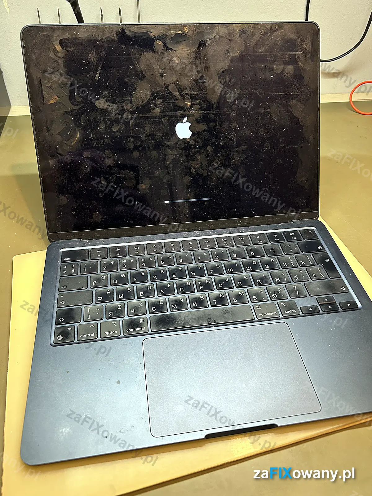 MacBook Air M2 przed naprawą, ekran pokryty odciskami palców i zabrudzona klawiatura