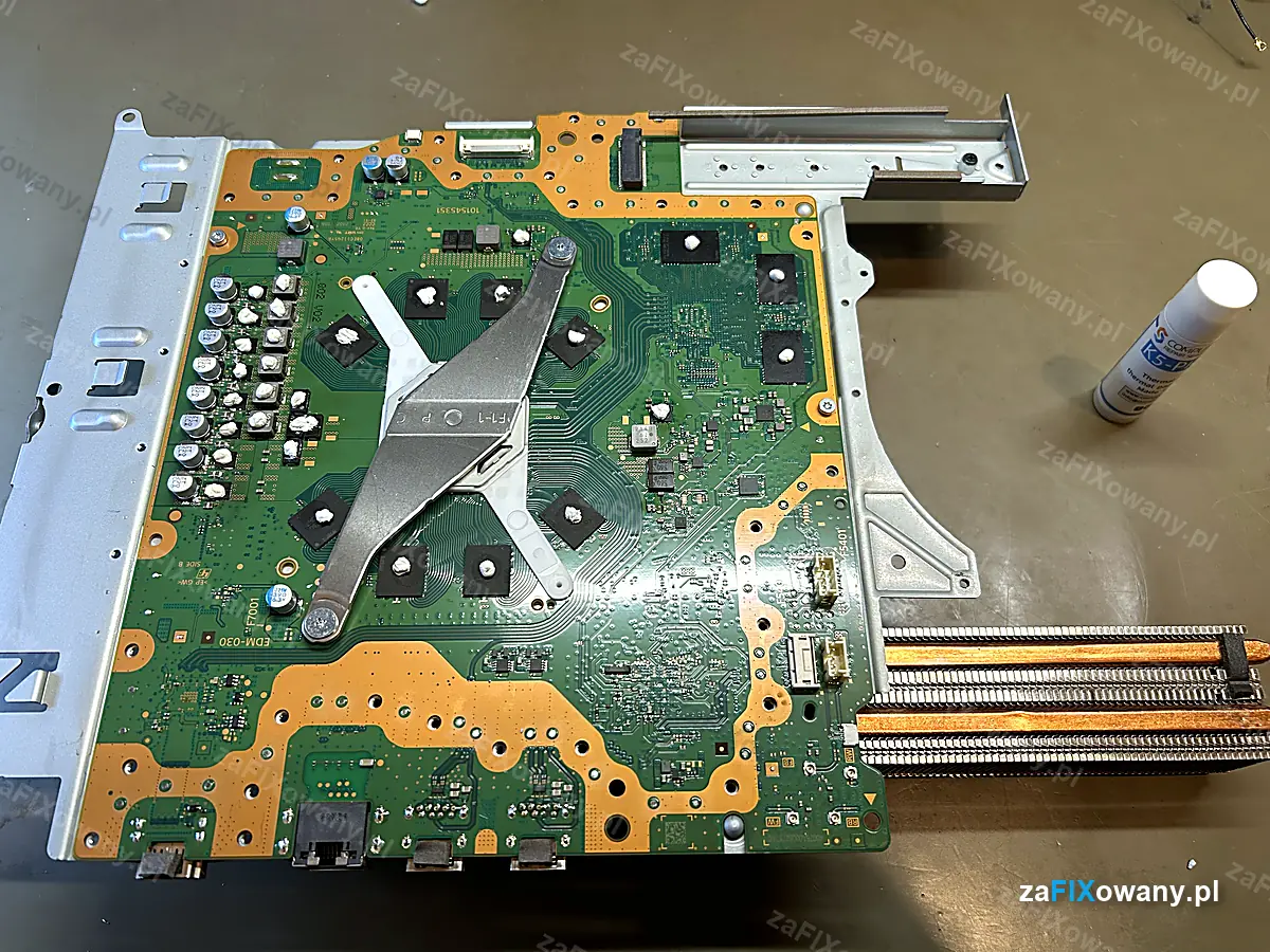 Pamięci VRAM i sekcja zasilania APU w PS5 z kulkami świeżo nałożonej masy K5-PRO, obok tubka K5-PRO