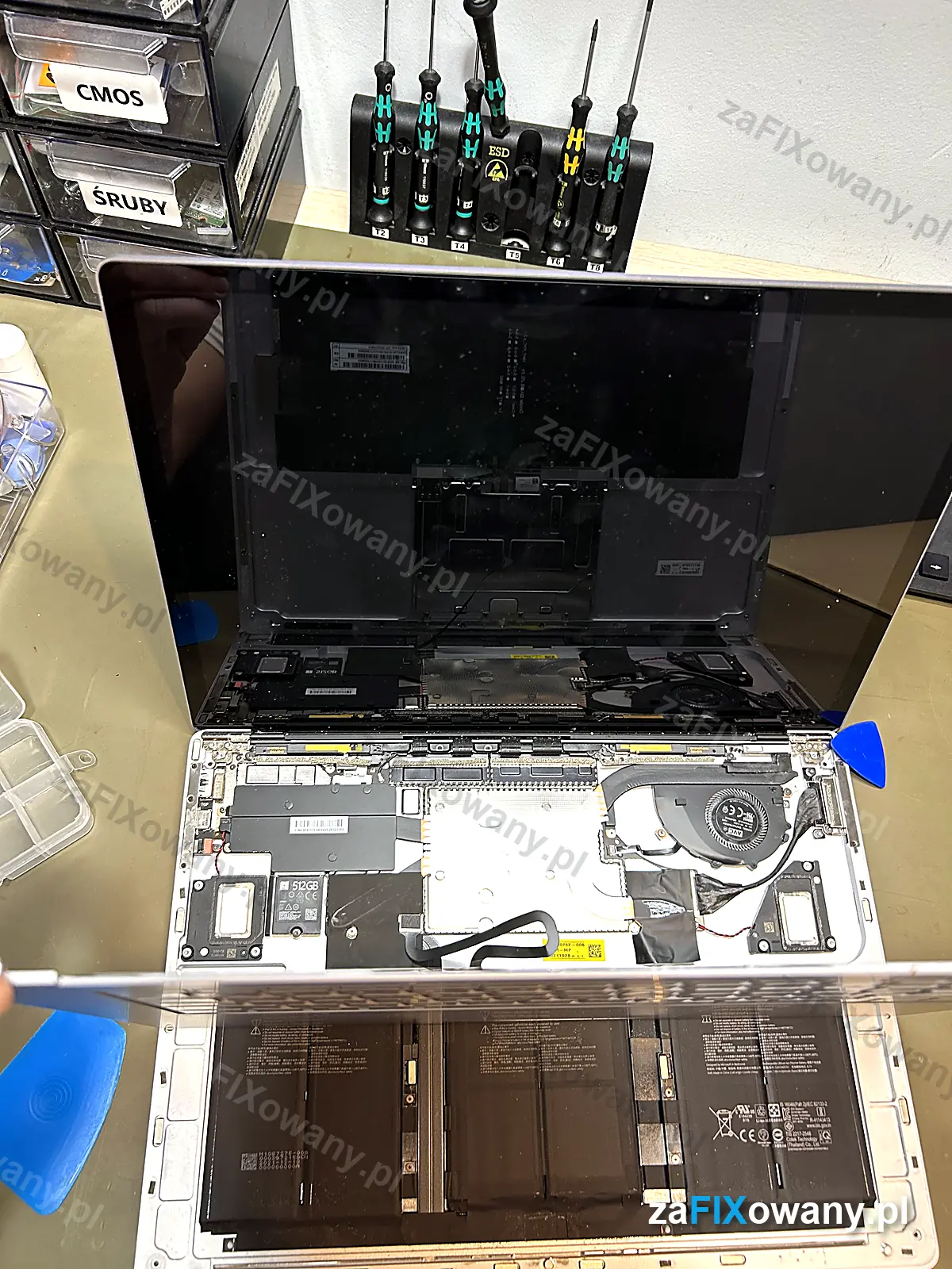 Otwarty Surface Laptop 3 ze zdjętą płytą klawiatury, widoczne baterie i płyta główna