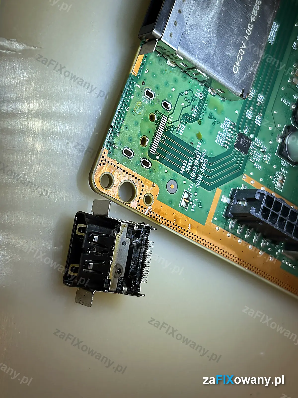 Wylutowany port HDMI leżący obok płyty głównej Xbox Series X