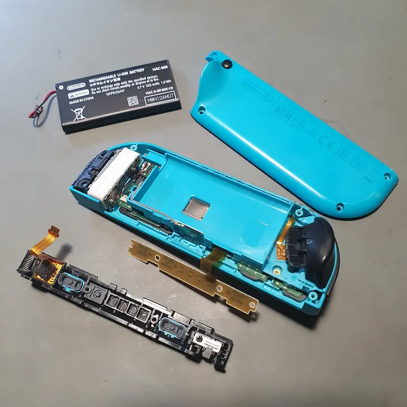 Wnętrze kontrolera Nintendo Joy-Con z widocznymi podzespołami przed naprawą dryfu gałki w serwisie we Wrocławiu.